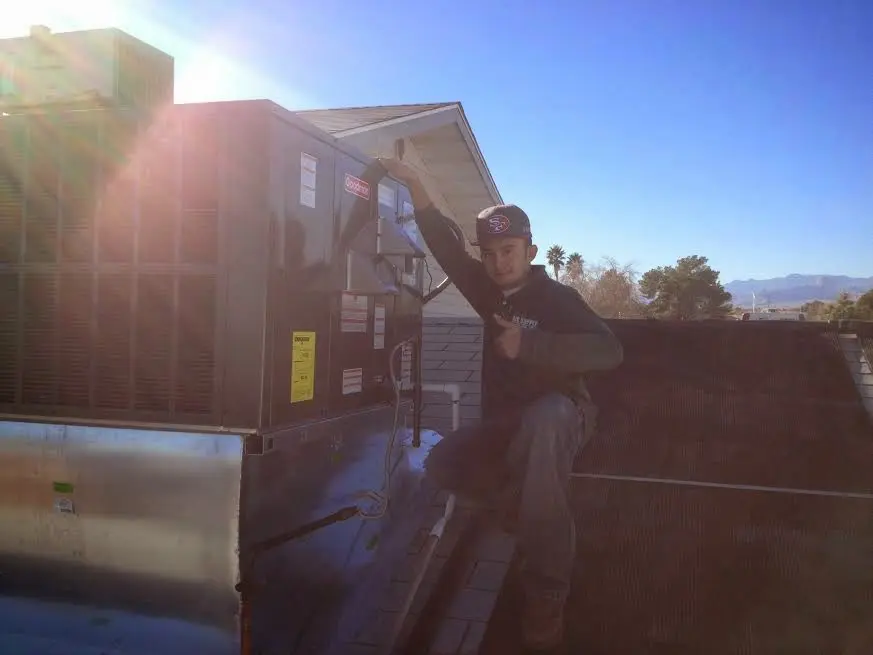 HVAC technician performing Air Duct Repair on a rooftop unit in Fairland